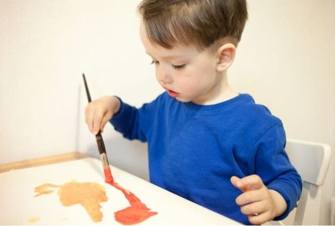 image enfant qui se concentre à faire de la peinture photo enfant qui se concentre à faire de la peinture